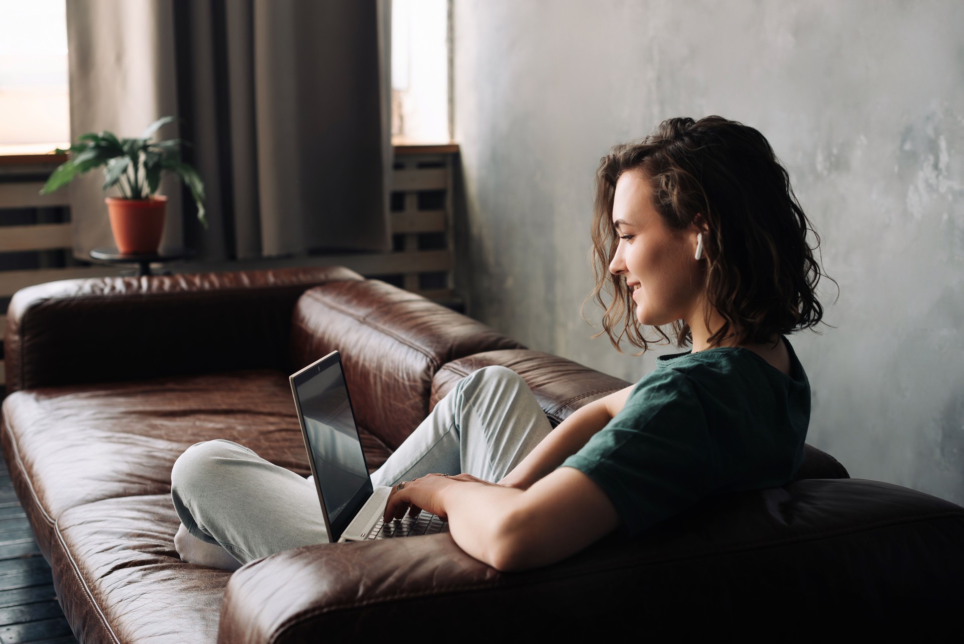 Young Woman Engaged in Remote Work or Study, Showcasing the Lifestyle of a Student or Freelancer, with Laptop and Modern Technology, Emphasizing the Work-From-Home and Business Concept.