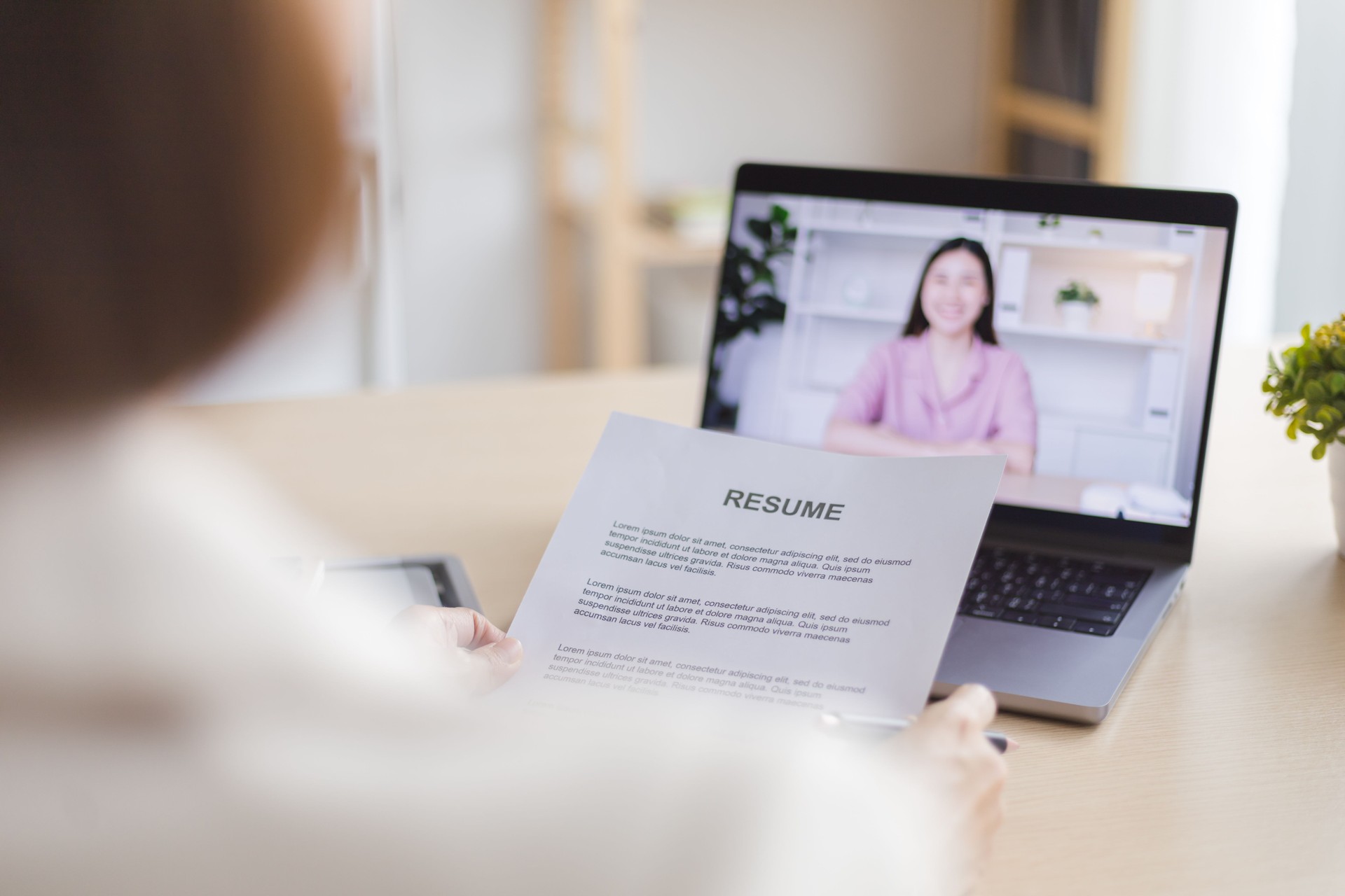 Confident Asian woman human resource interviewing a job candidate via video conference.